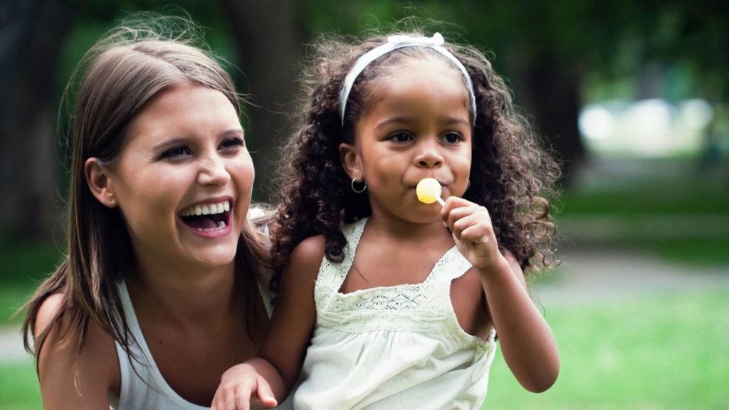 baby-sitter portant une petite fille