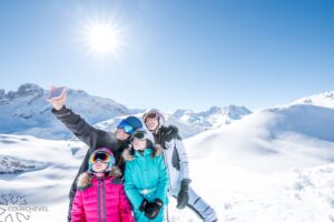Niños y niñera haciéndose una foto en las pistas de esquí