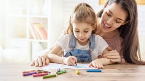 Enfant dessine avec sa baby-sitter