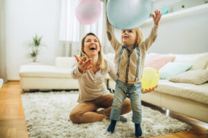 baby and babysitter playing with baloon